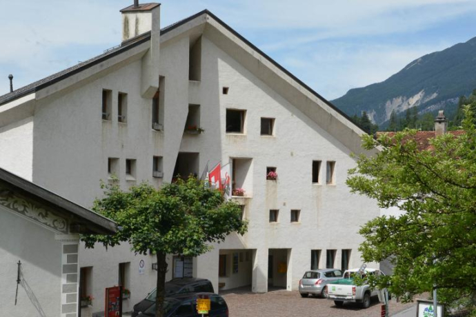 The parish hall does not copy the Engadine house, but reinterprets it.